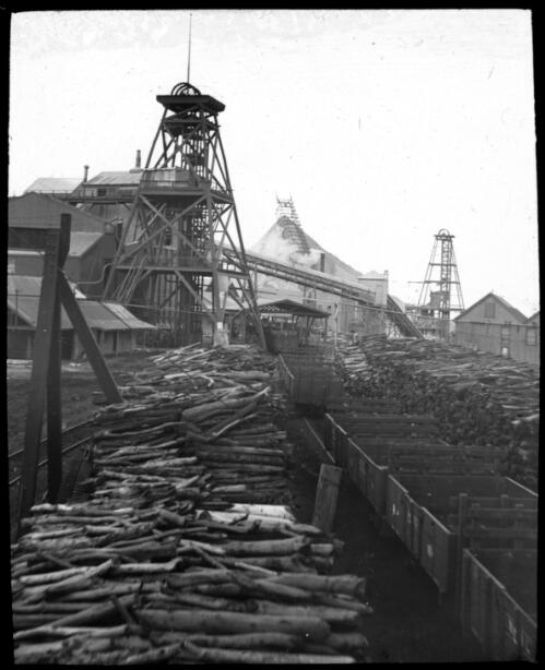Tree trunks stacked outside an unidentified mine [transparency] : part of mixed selection of lantern slides and negatives from John Flynn's teaching days in Gippsland, and early AIM [Australian Inland Mission] activities / John Flynn