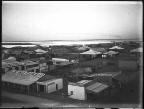 View of a town with buildings of A.H. Wilson & Co., Drapery & clothing [picture] : an image used by the Australian Inland Mission at Dunbar, Cape York / [John Flynn?]