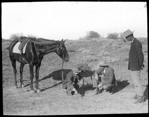 Unidentified men drawing maps in the sand [transparency] : a lantern slide used in lectures on all Australian Inland Mission activities / [John Flynn?]
