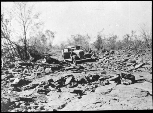 Car travelling over rocky road [transparency] : a lantern slide used in lectures on all Australian Inland Mission activities / [John Flynn?]