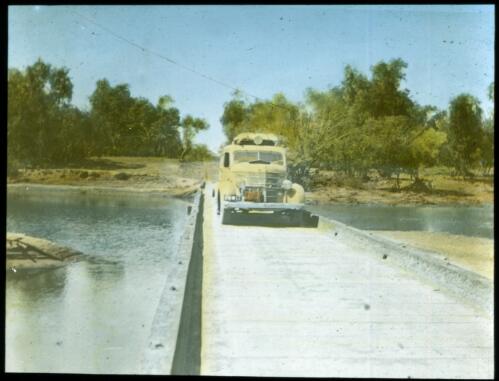 Yellow vehicle on Fitzroy Crossing causeway [transparency] : a lantern slide used in lectures on all Australian Inland Mission activities / [John Flynn?]