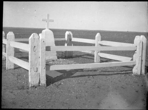 Unidentified grave surrounded by a white wooden fence [transparency] : taken during the Resonian trip to the Northern Territory led by John Flynn / [John Flynn?]