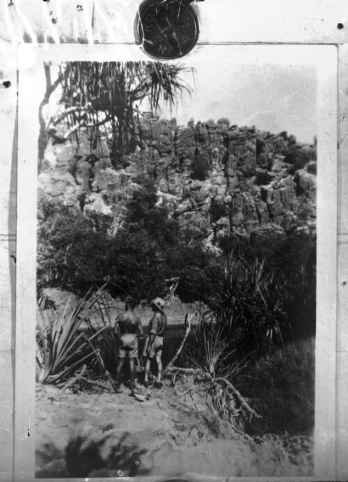 Two unidentified men standing beside a river in an unidentified gorge [picture] : scenes of the Birdsville area / [John Flynn?]