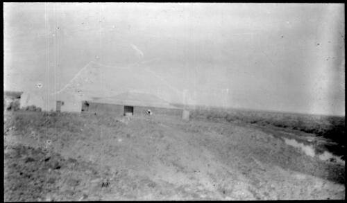 Two buildings near a river [transparency] : scenes in the Diamantina area and other general scenes / [John Flynn?]
