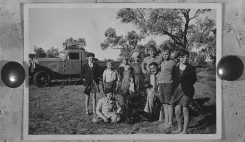 Reverend Fred McKay with the pedal-powered wireless surrounded by children, [1] [picture] : scenes around Cloncurry, 1938-1940 / [John Flynn?]