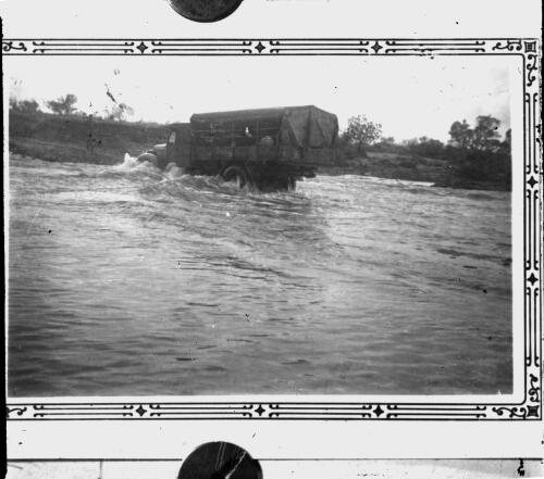 Truck crossing a river [picture] / [John Flynn?]