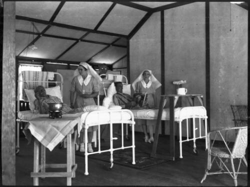 Nurses and patients in a hospital ward [picture] / [John Flynn?]