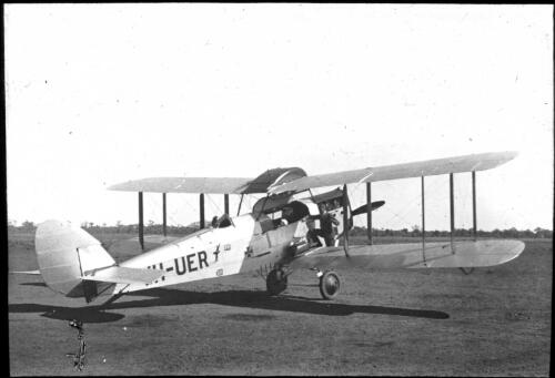 Dr. Allan Vickers standing with a patient beside Australian Inland Mission ambulance, DH5OA aircraft Victory, ca. 1932, 3 [transparency] / [John Flynn?]