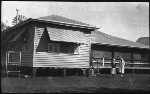 Two nurses standing in front of Bonlia hospital [transparency] : general Australian Inland Mission scenes / [John Flynn?]