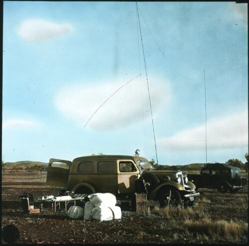 Two trucks with wireless antenna strung between them [transparency] : scenes of Tennant Creek and the Northern Territory, Beltana, Oodnadatta, and other general scenes / [John Flynn?]