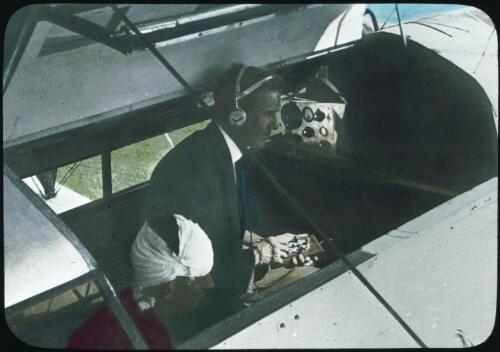 Dr. Vickers sending a message using the communications apparatus in an aeroplane of the Flying Doctor Service, ca. 1932 [transparency] / Rev. Andrew Barber