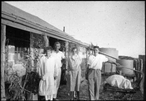 Group of unidentified people standing in front of Birdsville hospital [transparency] : general Australian Inland Mission scenes / [John Flynn?]