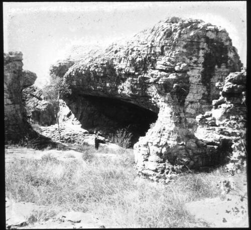 Cave in a rocky outcrop [transparency] / [John Flynn?]