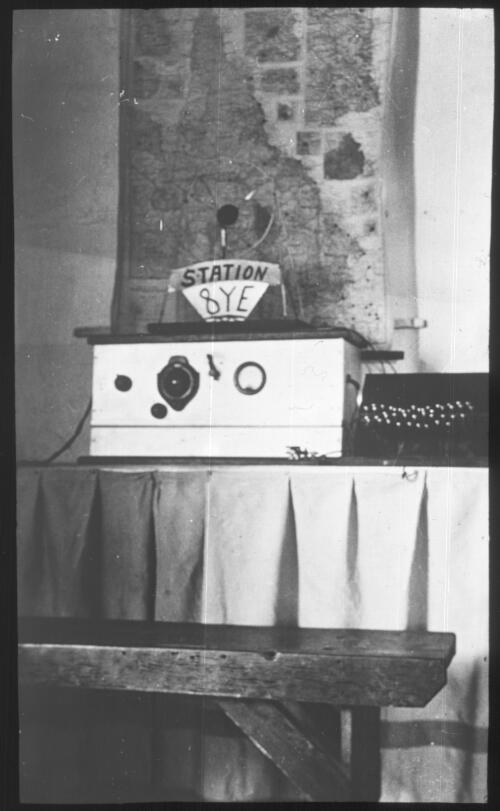 View of the station 8YE transmitter in front of a map of Queensland [transparency] : a lantern slide used in lectures on all Australian Inland Mission activities, [1940-]/ [John Flynn?]