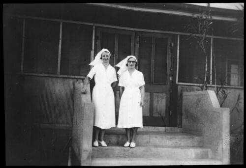 Two unidentified nurses on the front steps of a hospital [transparency] / [John Flynn?]