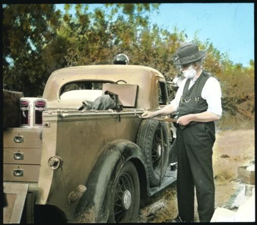 John Flynn having his 'early morning' shave beside Reverend Fred McKay's truck, at their Gilbert River campsite on the way to Dunbar, 1938 [transparency]