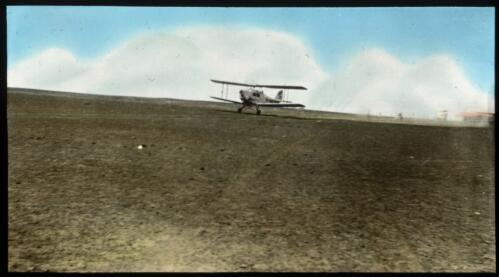 View of an plane taxiing in a paddock [transparency] : a lantern slide used in lectures on all Australian Inland Mission activities, / [John Flynn?]