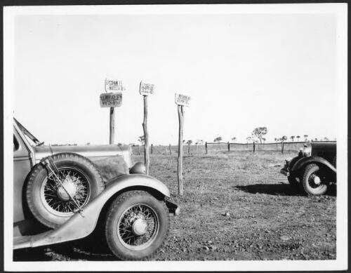 A group of interesting signs with portions of two cars on the Longreach-Winton road, Western Queensland [picture] : photographs taken by C.T.F. Goy during his North Australia patrol, 1937-1942 / C.T.F. Goy