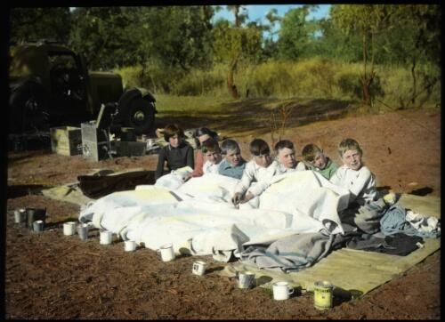 Group of children ready to sleep on a groundsheet at an A.I.M. Children's Camp, 1940 [transparency] / John Flynn