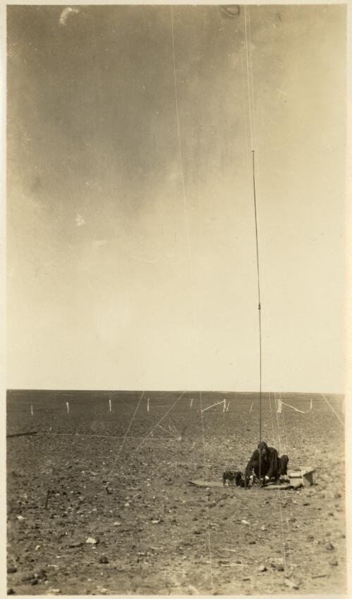 Unidentified man operating a wireless set with twenty metre antenna near Cordillo Downs [picture] / [John Flynn?]
