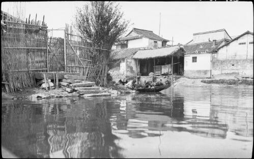 [Bamboo fence and gate with long stone steps to canal with a laden punt, China, ca. 1930 ] [picture] / Stanley O. Gregory