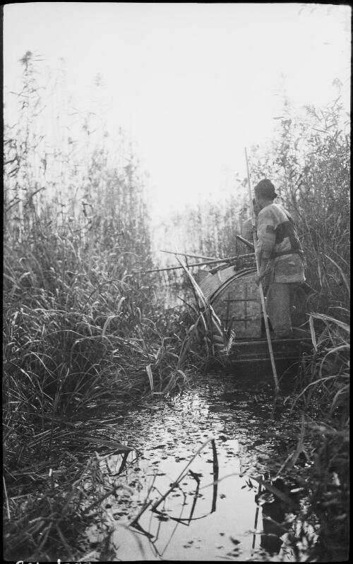 [Covered punt with figure on stern holding long fishing pole, China, ca. 1930] [picture] / Stanley O. Gregory