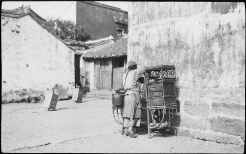 [Pedlar resting his wooden chest against a wall and two boxes the background, China, ca. 1930] [picture] / Stanley O. Gregory