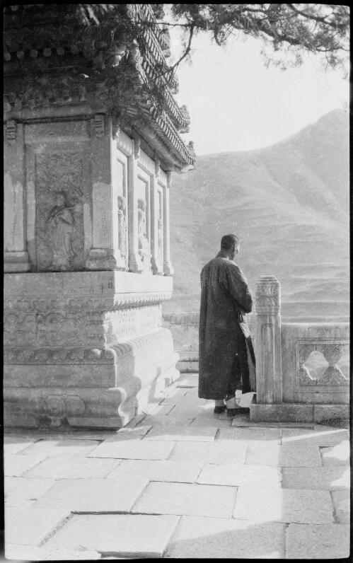 [Pi Jun Ssu temple in Peking with panelled carvings and a figure at the side looking to the bare mountains, China, ca. 1930] [picture] / Stanley O. Gregory