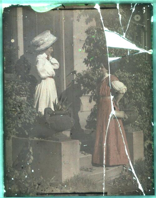 Two women in street costume at doorway of suburban house, ca. 1906] [transparency] / Lionel Lindsay