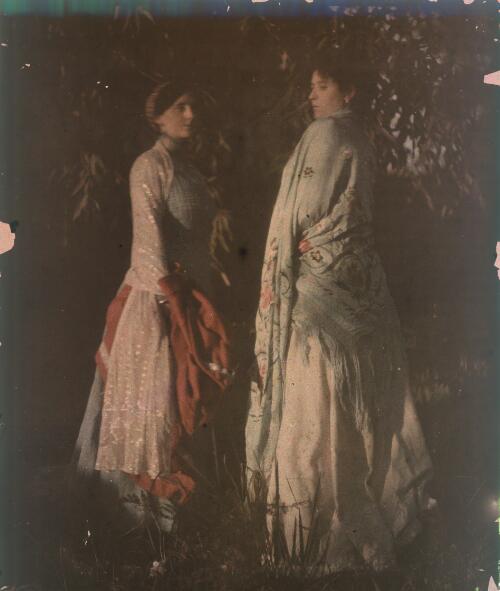 [Two unidentified women in a garden wearing dresses and shawls, ca. 1906] [transparency]