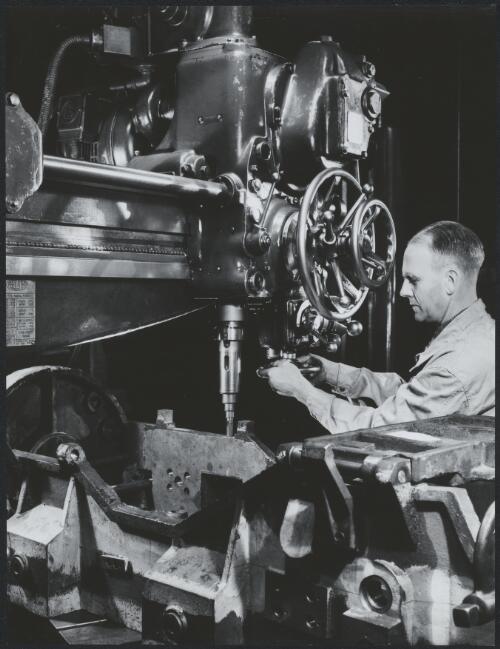 [Turning wheel on machinery at International Harvester, Geelong, Victoria], 1949 [picture] / Wolfgang Sievers