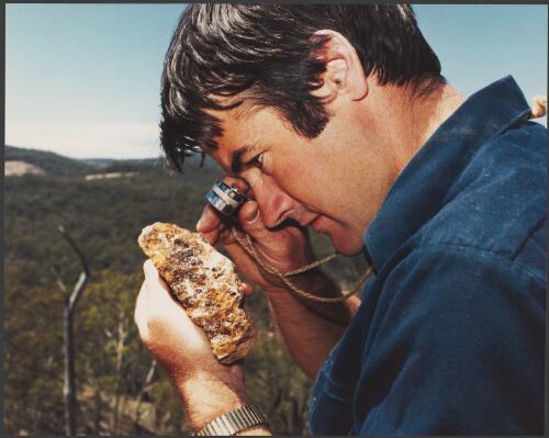 Shell geologist, Ian Wilson, examining rock from an old mining area near Orange, New South Wales, 1980, 1 [picture] / Wolfgang Sievers