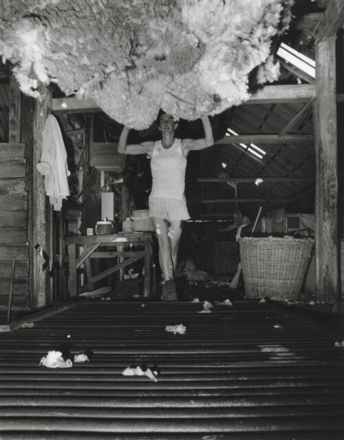 Debbie Stone, shearer's rouseabout throwing a fleece at Manar shearing shed, Manar, New South Wales, April 1998 [picture] / Terry Milligan