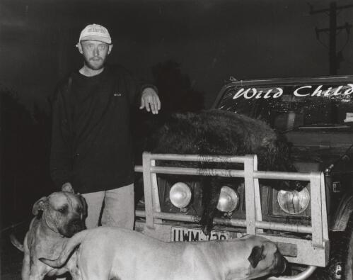 Kevin White, pig-hunter with dogs and a 85 kg boar caught near his property outside Braidwood, New South Wales, August 1998 [picture] / Terry Milligan