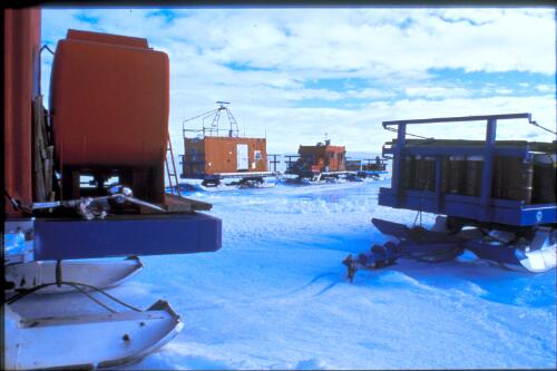 Traverse vans left on the plateau behind Mawson Station are used to transport expeditioners on extended research expeditions across the ice cap,   Mawson Station, Antarctica, 27 December 1997 [transparency] / Felicity Jenkins
