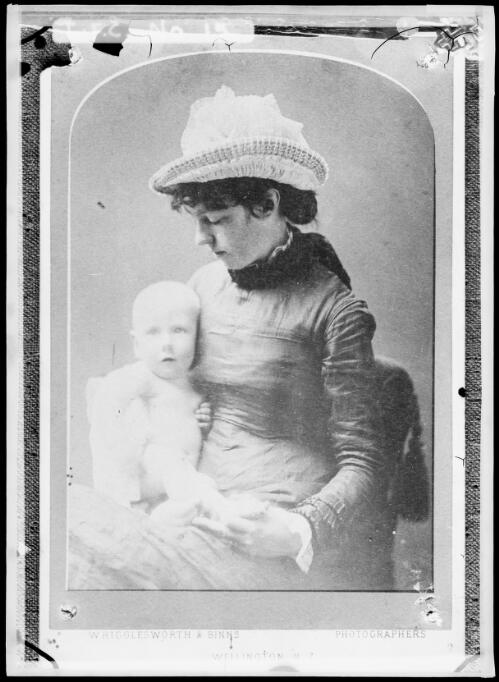 Emily Cazneau wearing a hat and holding baby King [picture] / Harold Cazneaux