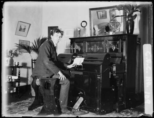 Harold Cazneaux at the new pianola in the dining room, North Sydney [picture] / Harold Cazneaux