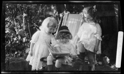 Beryl, Rainbow and Jean Cazneaux looking at a book, 1913? [picture] / Harold Cazneaux