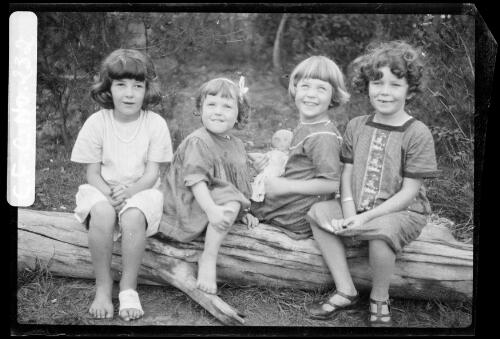 Jean, Rainbow, Beryl and Carmen sitting on a log, Ambleside, Roseville, New South Wales, 1916, 2 [picture] / Harold Cazneaux