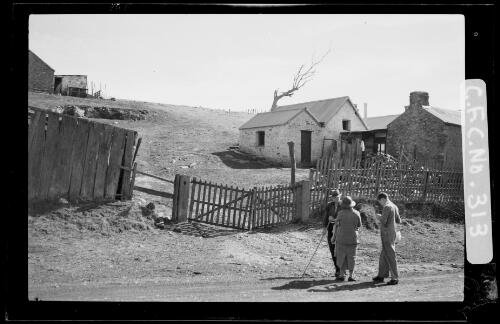 Winifred Cazneaux and her son Harold outside stone cottages, South Australia, 1937 [picture] / Harold Cazneaux