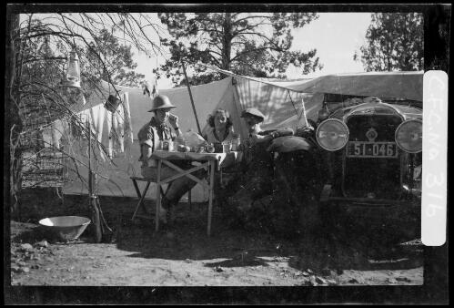 Harold Cazneaux with wife Winifred and son Harold eating at a table at their camp site in the Flinders Ranges, South Australia, 1937 [picture] / Harold Cazneaux
