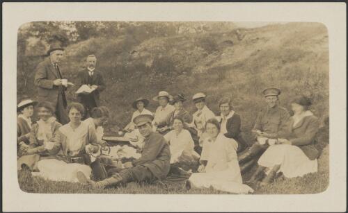 Twelve unidentified women, Charles Daley senior, standing on left, and three unidentified men, two in army uniform, having a picnic on the Yarra, Melbourne, 1917 [picture]