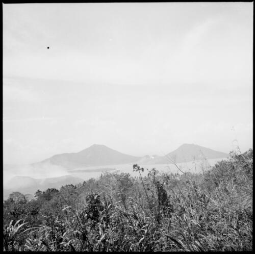Smoke rising from Vulcan Island after the eruption with Mother and South Daughter Mountains in distance, Rabaul Harbour, New Guinea, 1937 [picture] / Sarah Chinnery