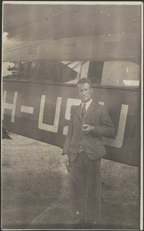 Sir Charles Kingsford Smith with a pipe standing beside the fuselage of the Southern Cross VH-USU, 1932 [picture]