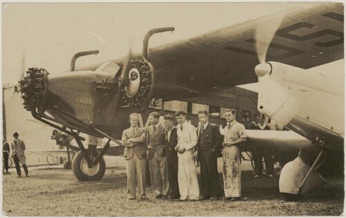 Charles Kingsford Smith, Pat Hall, Tommy Pethybridge, Bruce Cowan and John Stannage, standing next to Southern Cross (VH-USU), a Fokker F.VIIa/3m monoplane, ca. 1934 [picture]