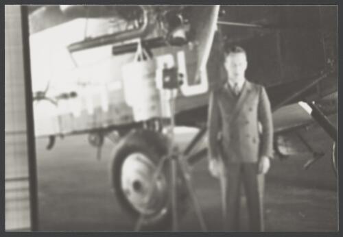 Charles Kingsford-Smith standing next to the Fokker F.VIIb/3m, Southern Cross, after his Trans-Tasman Jubilee Mail flight, Mascot Airport, Sydney, 15 May 1935 [picture] / E.A. Crome