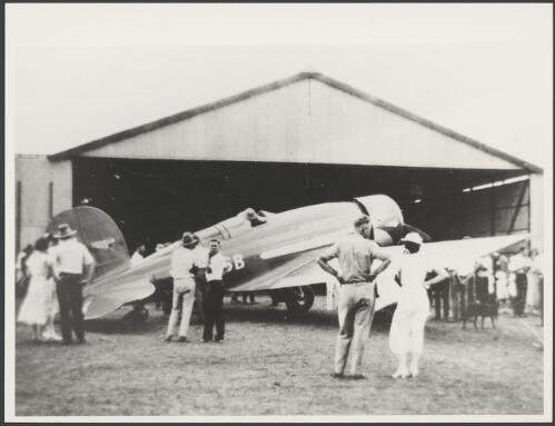 Spectators surrounding Charles Kingsford-Smith's Lockheed Altair monoplane, VH-USB, Lady Southern Cross, outside a hangar, Cloncurry, Queensland, September 1934 [picture]