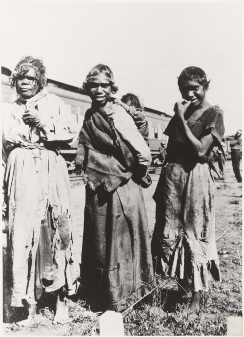 Group of three Everard Ranges Aboriginal women, one carrying a child on her back, at the Transcontinental railway line, Wynbring, South Australia, 1921 [picture]