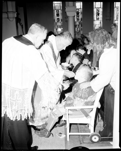 Children with a disability receiving communion bread at Blessed Sacrament Church, Clifton Gardens, 21 October, 1967 [picture] / John Mulligan