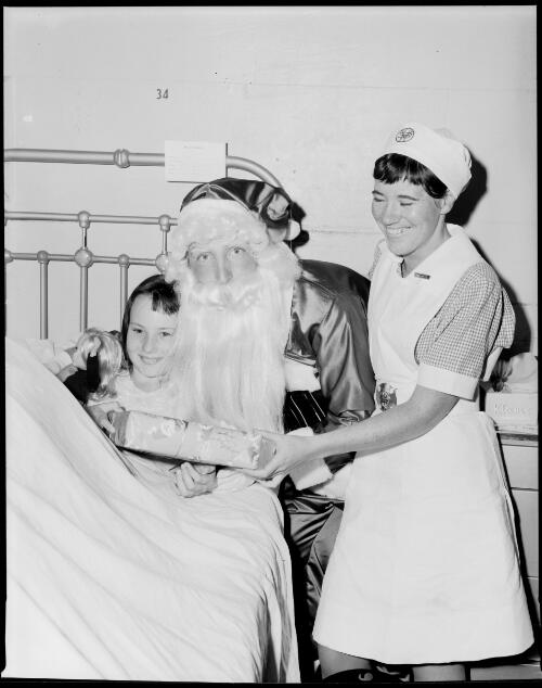 Santa with a child and nurse in the pediatric ward at St. Vincent's General Hospital, Sydney, 13 December, 1967 [1] [picture] / John Mulligan